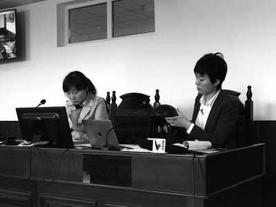 被告方查看原告出示的月月出事时所佩戴的头盔。京华时报记者郑羽佳摄