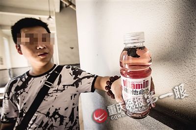 陈先生手中的饮料里,有明显的黑色块状物 陈先生手中的饮料里,有明显的黑色块状物