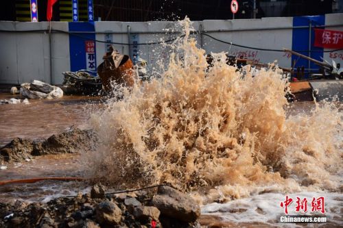 郑州街头水管爆裂水柱喷十米高 路人赤脚淌黄水