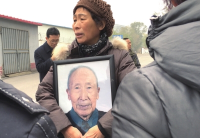 韩玉衡女儿手托遗像送别老人。京华时报记者谭青摄