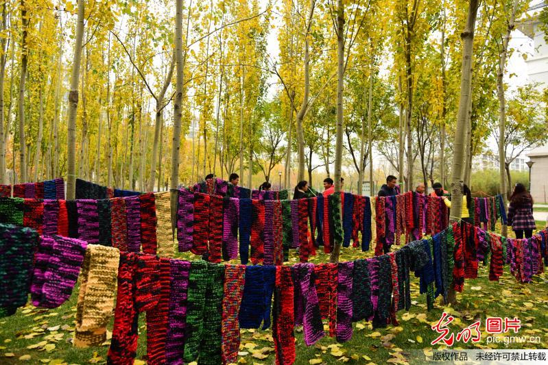 大学生卖报筹款 织500条围巾送环卫工