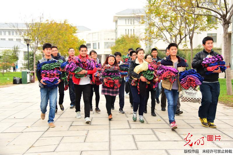 大学生卖报筹款 织500条围巾送环卫工