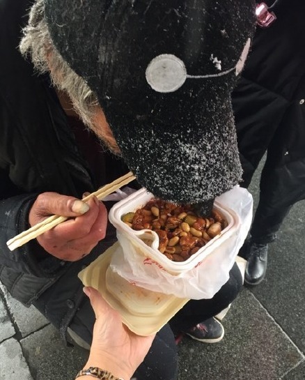流浪老人北京街头吃雪 好心路人买饭送衣