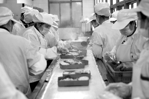 食堂工作人员将饭菜分装到餐盒里 现代快报记者 徐洋 摄