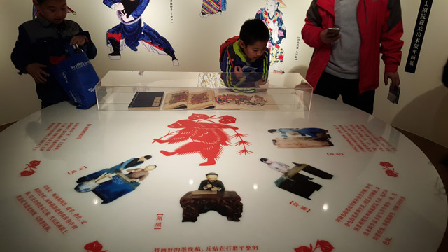 观众观看年画制作工序。-千龙网实习记者-梁祎摄