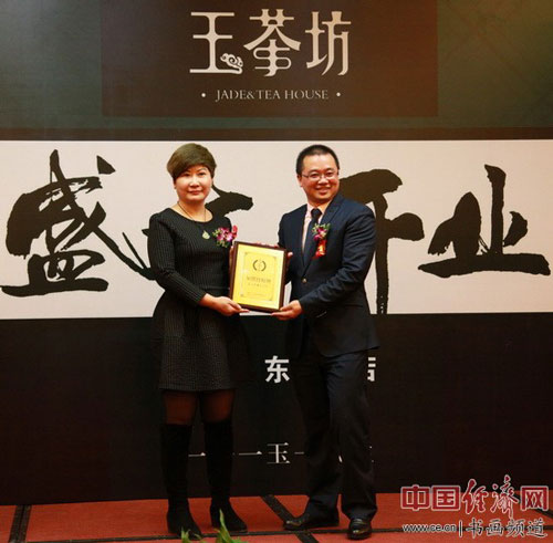 杭州三三玉茶坊企业管理有限公司总经理胡学明(右)向北京玉茶坊董事长安燕梅(左)授牌