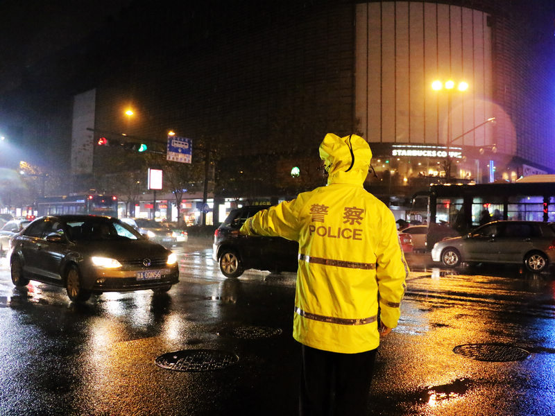 阴雨天气撞上节日，杭州的路面交通情况不容乐观，特别是在湖滨中队辖区的解放路、庆春路一带，车流量从下午开始就居高不下，一直到晚上近10点才逐渐开始舒缓起来。为此，湖滨中队的14名交警在12月24日、25日两天几乎全员加班。晚上9点20分左右，张楗平从解放路赶到了在延安路龙翔服饰城附近的路口疏散交通。晚上10点左右，杭城的小雨又飘了起来。张楗平拉上了制服上的雨帽，继续在路中央指挥交通。杭城最繁华地段之一的延安商业圈与他只有二十米之隔，可他工作以来从没有在节假日进去过。 郭扬 摄