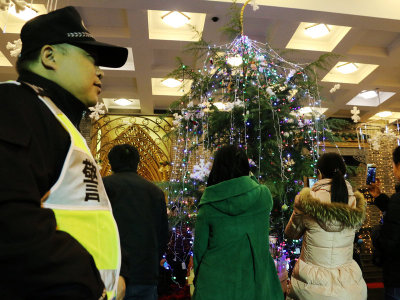 在鼓楼堂中，圣诞节的浓郁的气息扑面而来，但对于朱炯明来说，节假日就是他们的&ldquo;战场&rdquo;。&ldquo;我们要时刻眼观六路、耳听八方。&rdquo;朱炯明说，因为天气的原因，今天来教堂聚会的市民比以往少了许多，但仍有近千人。雨天地滑会产生一些安全隐患，我们得时刻注意。&rdquo;对于朱炯明来说，今天也是一个特殊的日子&mdash;&mdash;他的生日，但因为工作的原因，他没有办法和家人团聚、庆贺。朱炯明说，这已经是他连续第八个年在教堂过生日了。 郭扬 摄