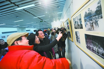  昨天下午，北京市少年宫邀请老组员和退休教师代表走进市少年宫新址，一同观看&ldquo;我们共同走过60年&mdash;&mdash;教学成果汇报演出&rdquo;，庆祝即将到来的市少年宫成立60周年纪念日。图为中国足球名宿金志扬与老组员们观看市少年宫60年历史图片展，饶有兴致地回忆当年在少年宫的学习生活。本报记者 孙戉摄