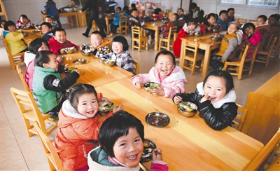 12月25日，蒲江县蜈蚣村幼儿园的小朋友们在教室里吃饭。