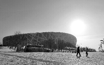 28日上午，鸟巢外积雪未化，前来游玩的市民沐浴在阳光下
