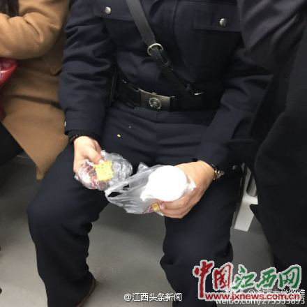 男子在地铁内一手拿豆浆，一手抓馒头。