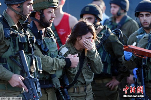当地时间11月23日，一名以色列女兵在约旦河西岸遭刺杀，其同僚在遇难者葬礼上哭泣。