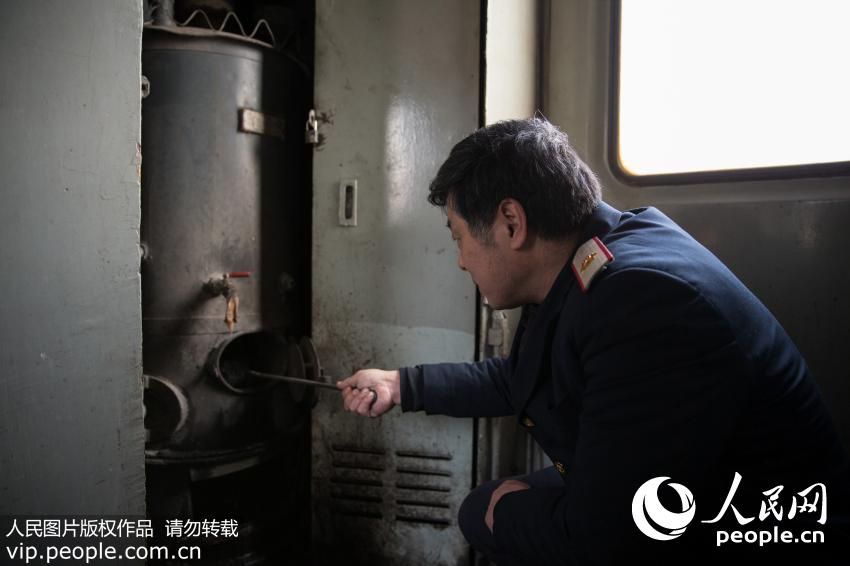2016年1月3日，茶水员张忠良正在列车上烧开水。