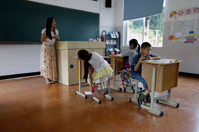 教室里，邵老师在认真给三年级学生上语文课。 由于山区蚊子多，影响了孩子上课专注。 图片由cfp授权使用，严禁转载
