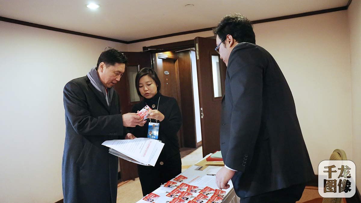 1月20日，政协委员耿晓冬在报到处领取会议材料和证件。千龙网记者 王璟玥摄