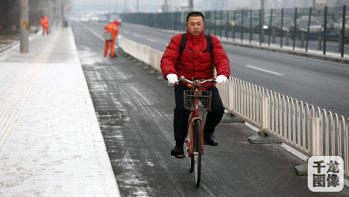 北京市十四届人大四次会议将于1月22日开幕。1月21日上午9时许，人大代表们陆续抵达驻地。东城代表团代表任素永连续四年骑车赶往会场报到。千龙网记者 王悦摄