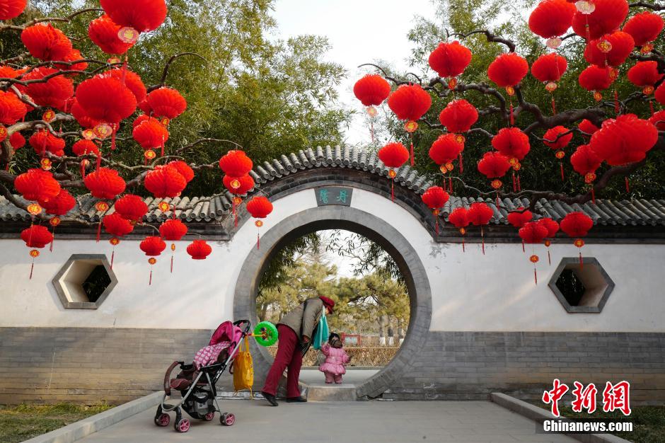 1月29日，一位老人带着小孩在地坛公园内游玩。随着中国传统节日春节的临近，北京各地开始增添新年装饰，增加喜庆气氛。传统的地坛庙会新年期间将如期举行。 中新社记者 侯宇 摄