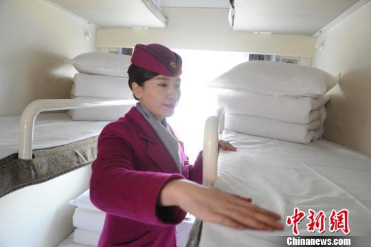 在兰州开往上海的Z218次列车上，列车员将洗涤厂清洗干净的被件铺到铺位上。　杨艳敏　摄