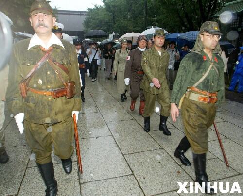 战后60年来，日本政府不但没有对其侵略行为进行认真的反思，反而一而再、再而三地在诸如参拜靖国神社、历史教课书等问题上歪曲历史、误导国民。这是2003年8月15日，披挂二战期间日军装束的右翼分子前往靖国神社参拜。当天是日本战败58周年纪念日。 新华社发