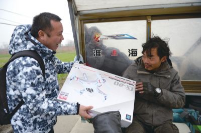 本报记者将航拍器送到丁一舟手中。