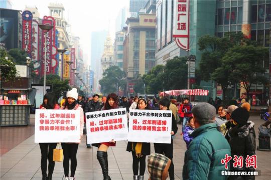 资料图：2015年2月4日，几位女青年手举标语出现在上海闹市区，无声地抗议亲友的逼婚行为，其标语上写着“妈，过年回家别逼婚。我的幸福我主宰！”中新社发章渝摄图片来源：CNSPHOTO