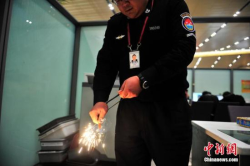 2月5日,工作人员展示查获的引火镁棒。当日,昆明长水国际机场安检站工作人员,向记者展示春运开始13天以来,查堵下的如皮带扣打火机、iPhone造型打火机、手表打火机、烟花爆竹、子弹等各种奇葩违禁物品。