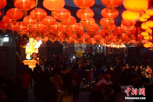 2015年2月18日晚，正值中国羊年春节的除夕夜，湖南凤凰古城迎春灯会起亮，极具特色的各式花灯争奇斗艳。五光十色的“夜凤凰”璀璨迷人，游客陶醉其中。 杨华峰 摄