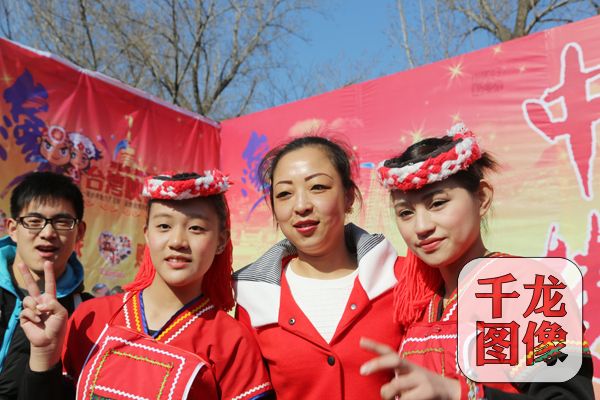 猴年春节期间,北京地坛庙会上,热情的台湾姑娘与游客合影。千龙网王路摄