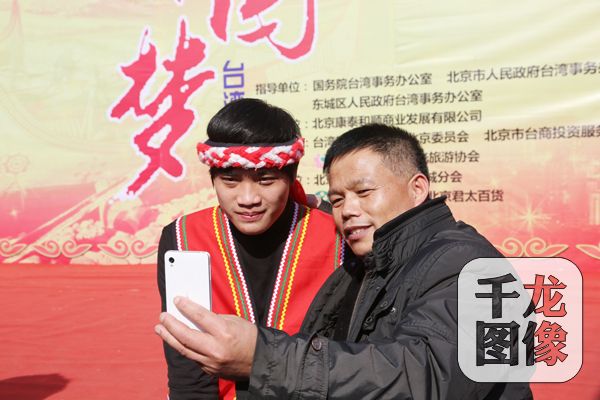 第五届台湾映像魅力展上，略显羞涩的台湾小伙与游客合影。千龙网王路摄