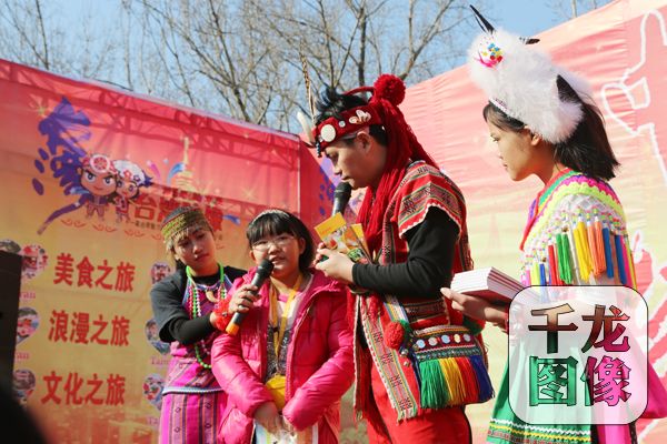 北京地坛庙会上,台湾花莲漂流木文化艺术团团员与游客互动。千龙网王路摄