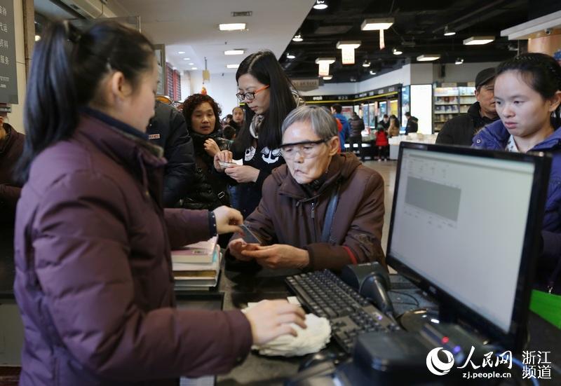 图书管理员接过这位老奶奶手中的市民卡。