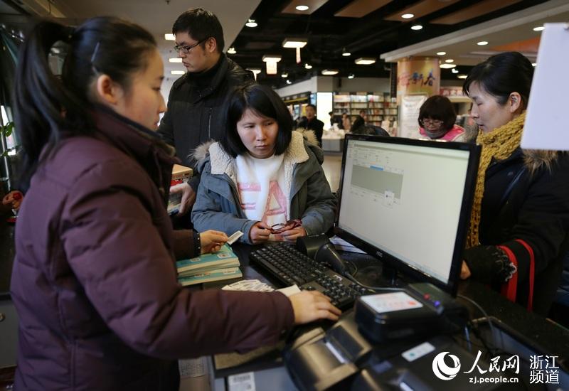 书店服务员帮助市民查阅该书是否可外借。