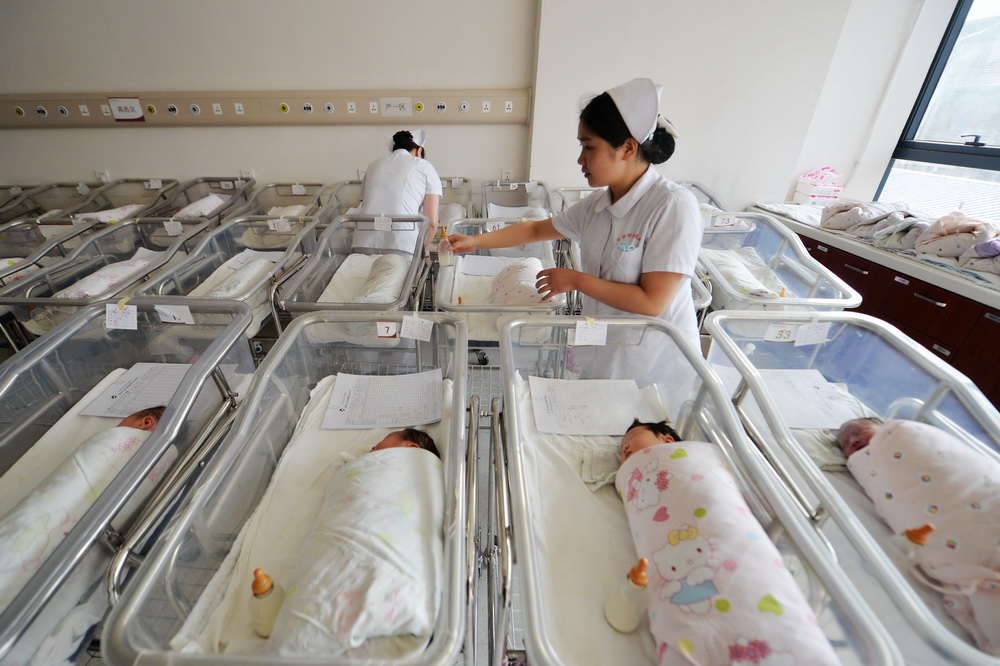 2月17日，甘肃省妇幼保健院产科护士李祖元（右）在新生儿护理区照顾刚出生的宝宝。