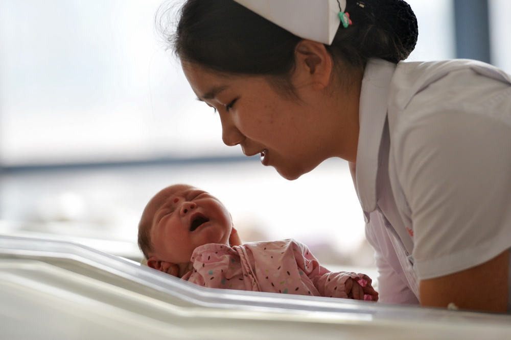 2月17日，甘肃省妇幼保健院产科护士在新生儿护理区照顾刚出生的宝宝。
