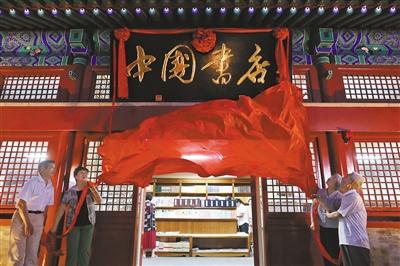 资料图：北京雁翅楼迎来西城区首家24小时书店，嘉宾们拉下红布为中国书店揭牌。 图片来源：新京报 记者 薛珺 摄