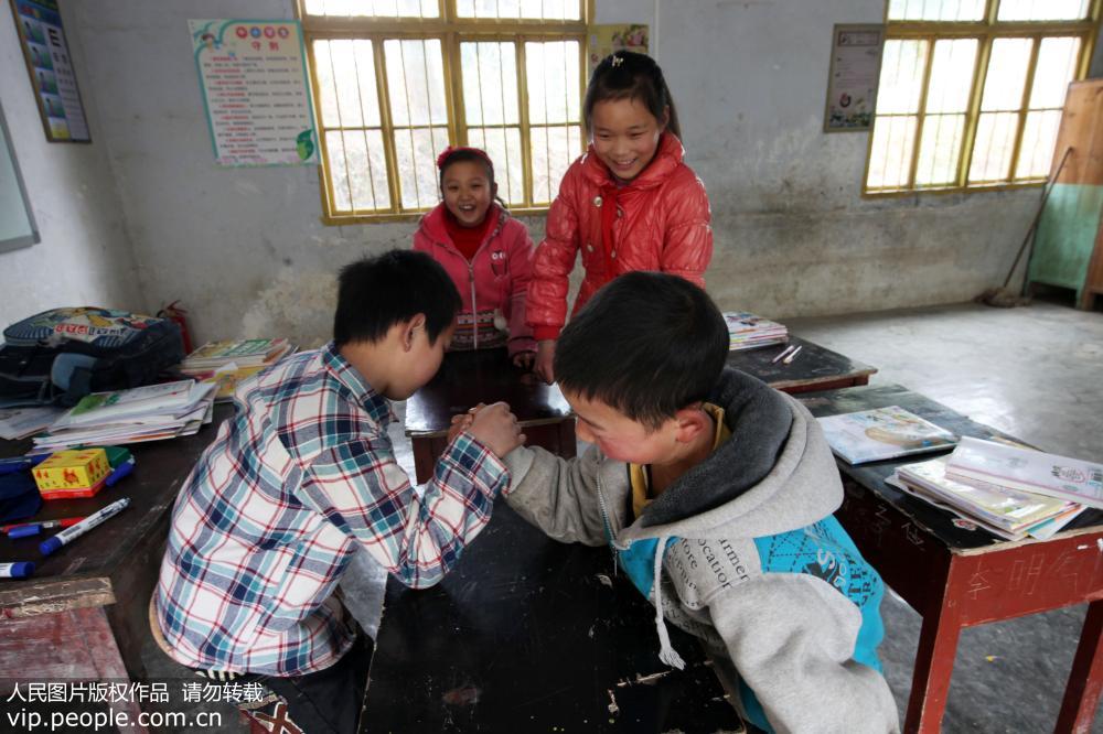 2月24日，重庆市黔江区水市乡新安村小学4年级仅有的4名学生在课间做扳手腕的游戏。