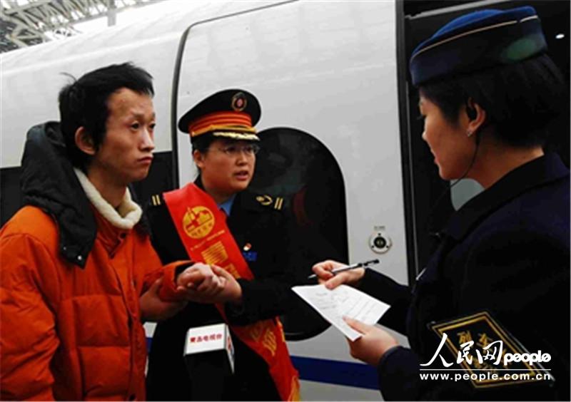 孙梅和列车长办理《重点旅客交接单》。