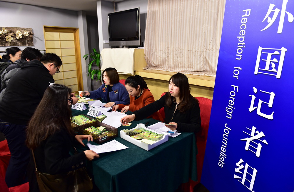3月1日，两会新闻中心外国记者组的工作人员在发放记者证。