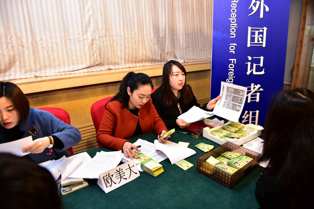 3月1日，两会新闻中心外国记者组的工作人员在发放记者证。