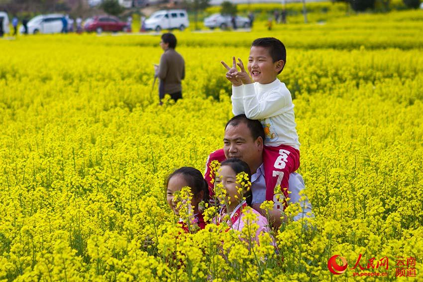 3月5日，游客在昆明安宁市青龙街道赵家庄村委会油菜花田中游玩。（人民网 李发兴 摄）