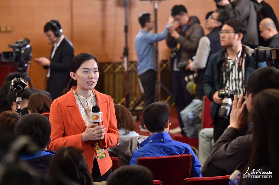 3月6日，在“政协委员谈适应引领新常态推进供给侧结构性改革”的记者会现场，女记者手拿话筒进行现场播报。（人民网记者 翁奇羽 摄）