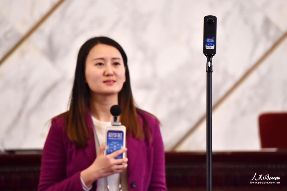 3月2日，在全国政协十二届四次会议新闻发布会现场，女记者正使用全景设备拍摄发布会现场。（人民网记者 翁奇羽 摄）