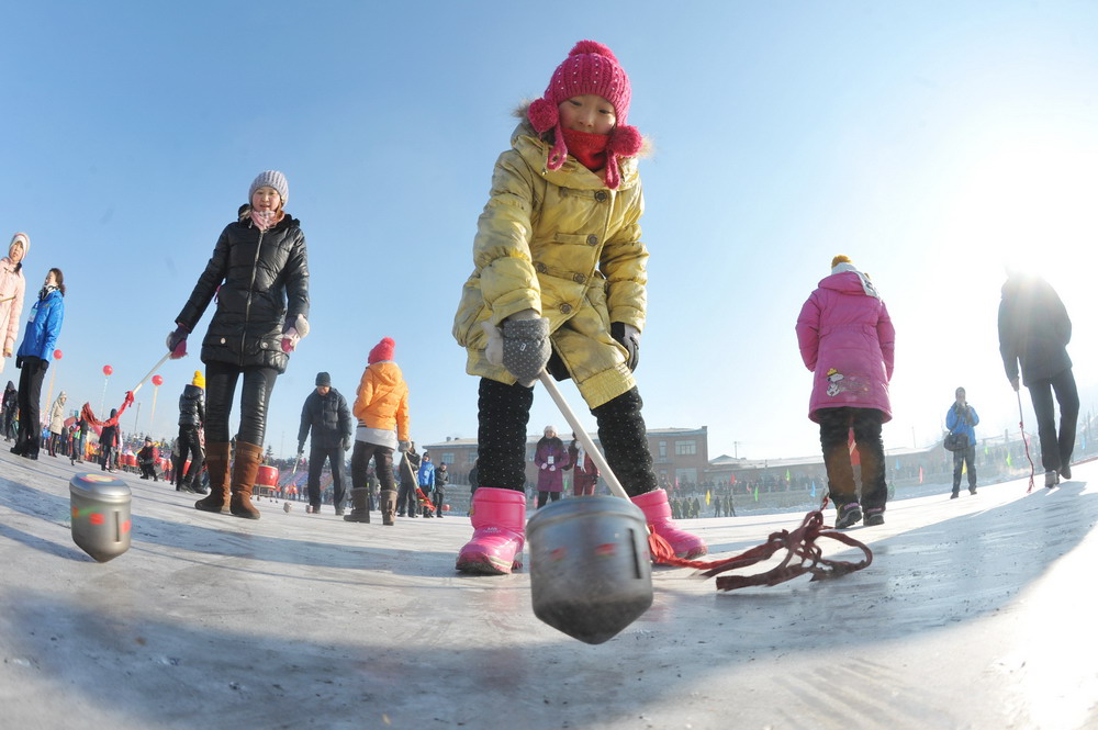 图为2012年2月23日农历二月二，在伊春市首届冰雪龙舟赛上，孩子们在进行抽冰尜比赛。新华社发