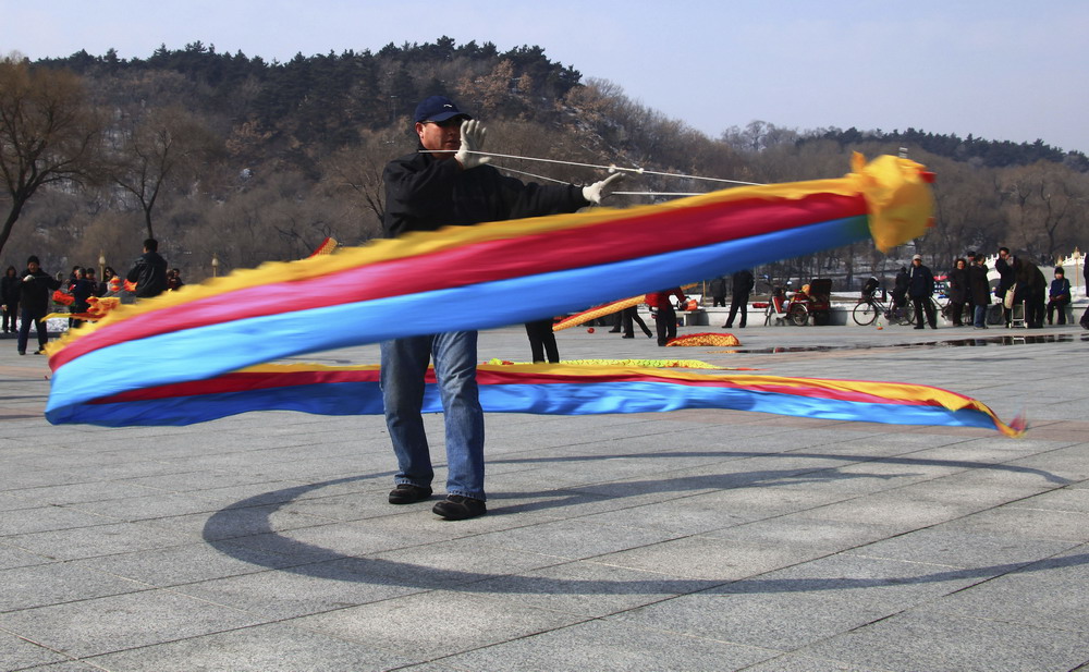图为2011年3月6日农历二月初二，一位空竹爱好者在吉林市人民广场抖空竹，空竹上挂着十来米长的软体龙凤，随着空竹上下翻滚，龙飞凤舞。 新华社发