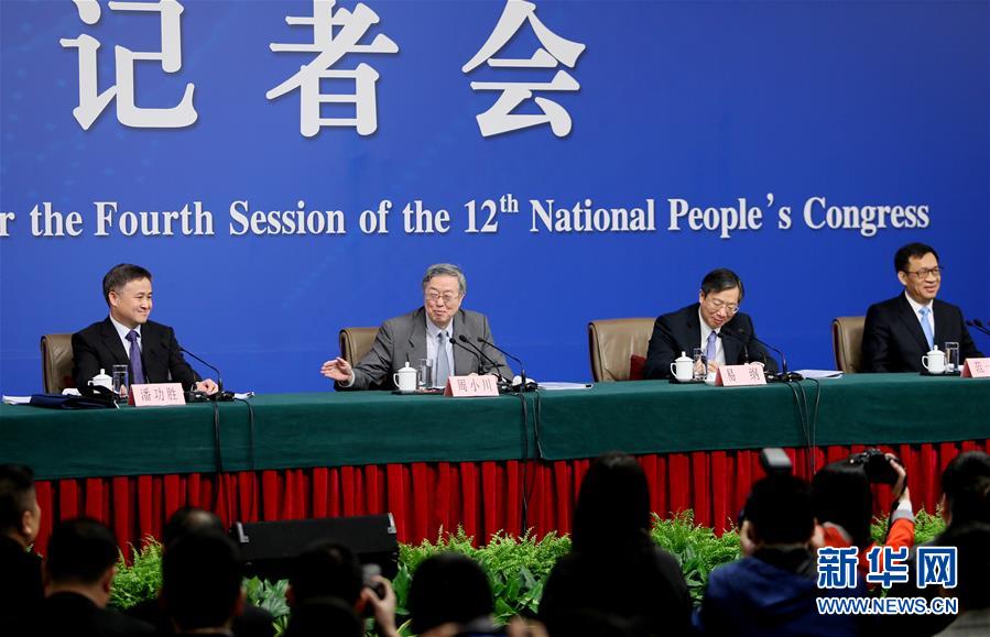 3月12日，十二届全国人大四次会议新闻中心举行记者会，邀请中国人民银行行长周小川、副行长易纲、副行长兼国家外汇管理局局长潘功胜、副行长范一飞就“金融改革与发展”的相关问题回答中外记者的提问。这是周小川（左二）介绍几位副行长。新华社记者陈君清摄