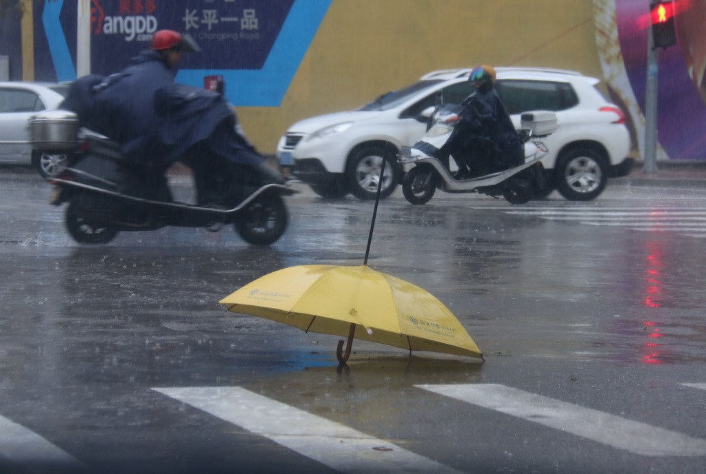 3月21日，广东汕头持续降雨，市民冒雨出行。 新华社发（姚军 摄）