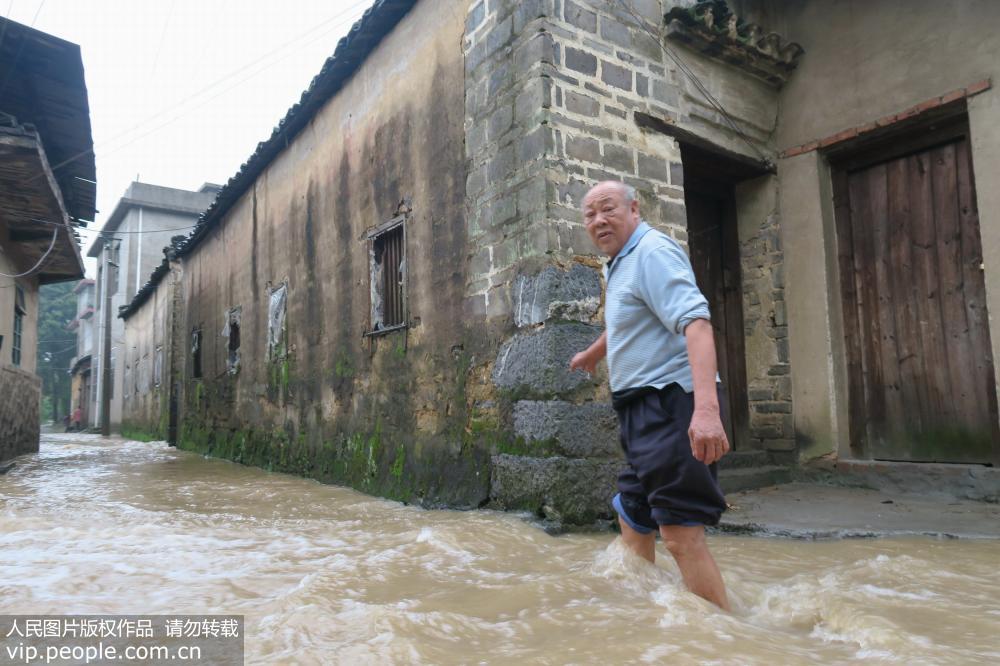 4月6日，广西全州县永岁乡上永岁村一村民在洪水中出行。