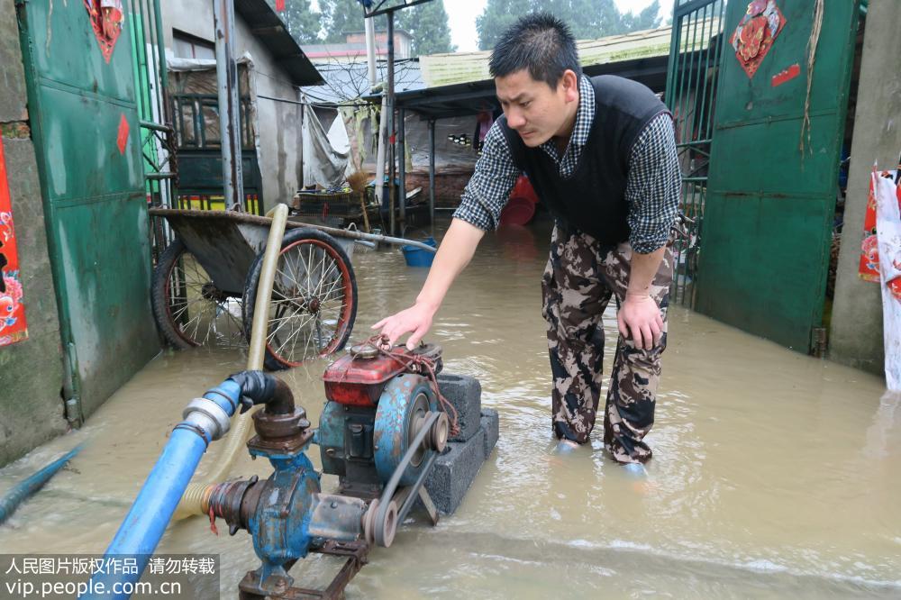 4月6日，广西全州县永岁乡上永岁村的一家养猪场浸泡在洪水中，场主宾浩用抽水机排水。