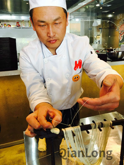 拉面师抻出的面条细得可以穿